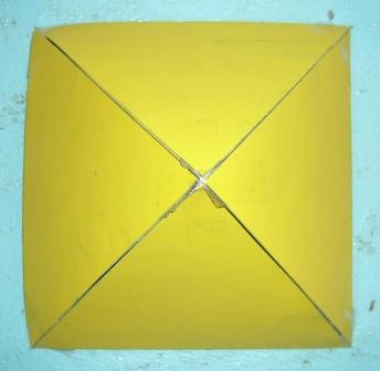 A yellow square divided into four triangular sections by crossed white lines, resembling a simplified celestial chart.
