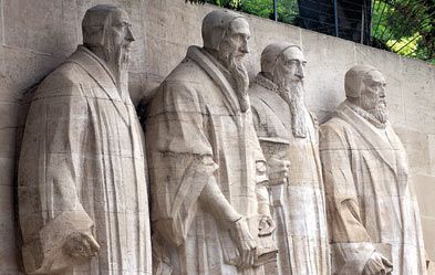 A sculpture of five solemn, bearded figures carved in relief against a concrete wall, each representing historical figures who contributed to the understanding of the heavens and the Mazzaroth.