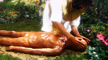 A scene depicting a person with dark hair, wearing a white robe, kneeling and tending to a golden human-like sculpture lying on the ground amid a vibrant garden filled with colorful flowers.