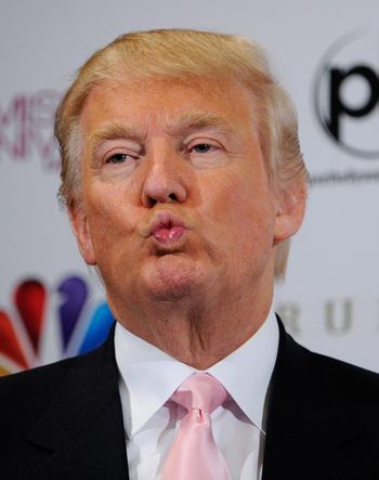 A man with light skin and combed blond hair wearing a light pink tie and a white shirt under a dark suit jacket, puckering his lips.