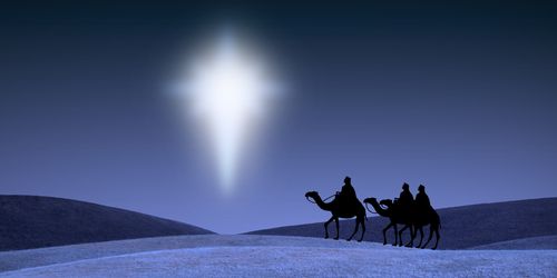 A serene night landscape shows three figures on camels traveling across a snowy field under a brilliant celestial light piercing the dark sky.