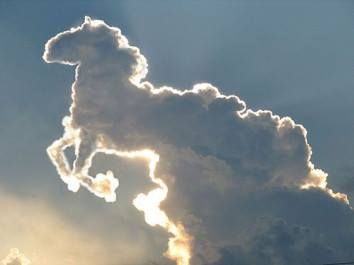 A cloud formation resembling a creature from the Mazzaroth, highlighted by the sun's rays at the edge, set against a dimming sky.