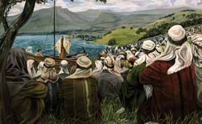 An artistic depiction of a historical biblical event where a large group of diverse individuals gathers by a serene lake, listening intently to a figure speaking from a modest wooden boat. The scene is set amidst verdant hills under a partly cloudy sky.