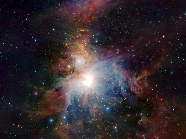 A detailed image of a vibrant nebula, showcasing various hues of blues, oranges, and whites, with diffused light emanating from a bright central star. The celestial scene is dotted with numerous stars and is surrounded by an intricate mixture of gaseous swirls and dust clouds.