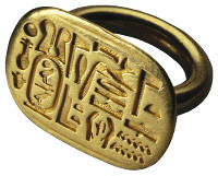 An ancient ring featuring detailed carvings that include symbols and hatchings, crafted in gold.