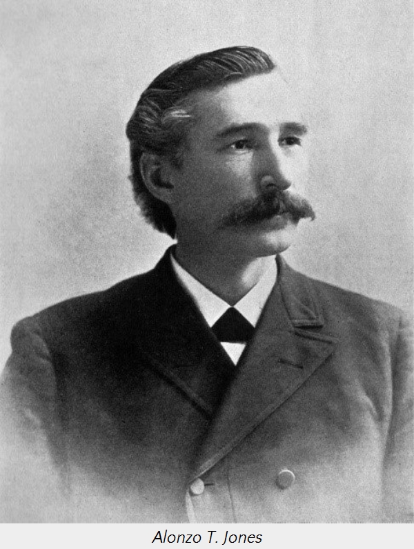 Black and white portrait of Alonzo T. Jones, a man with a distinct handlebar mustache, dressed in a late 19th-century dark suit and vest with a formal white shirt and tie. He is looking to his left with a gentle expression.